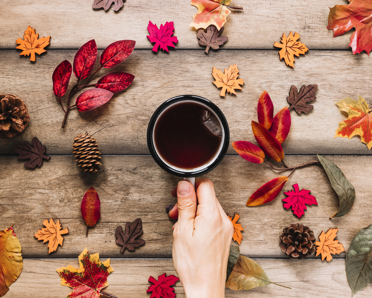 Кружка чая на столе с осенними листьями