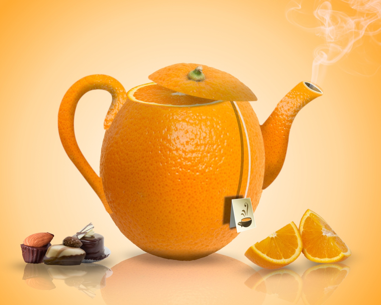 Чайник апельсин на оранжевом фоне с конфетами
