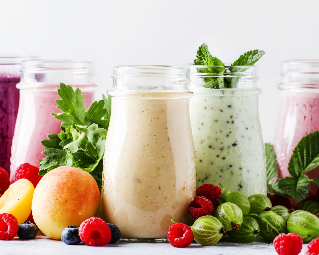 Банки со смузи на столе с ягодами 