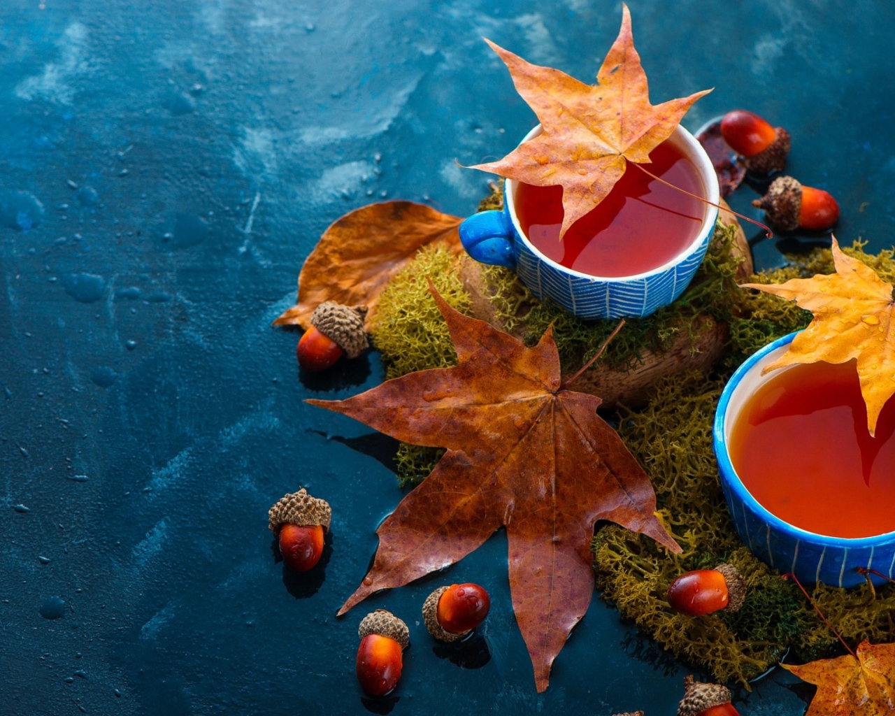 Чай на столе с осенними листьями и желудями 