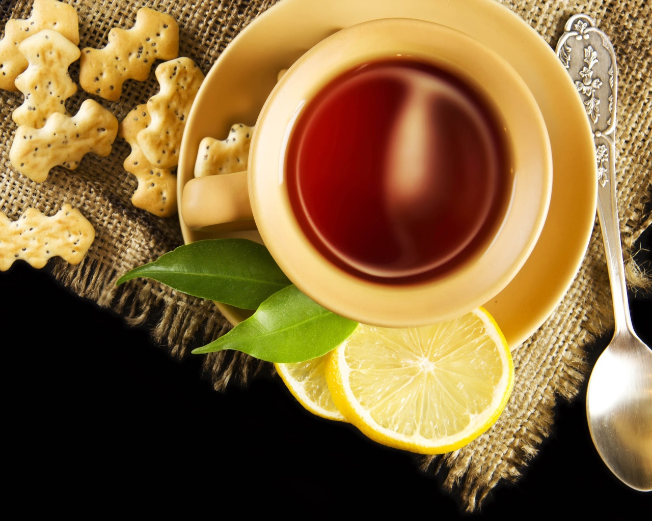 Чай на столе с печеньем и кусочками лимона