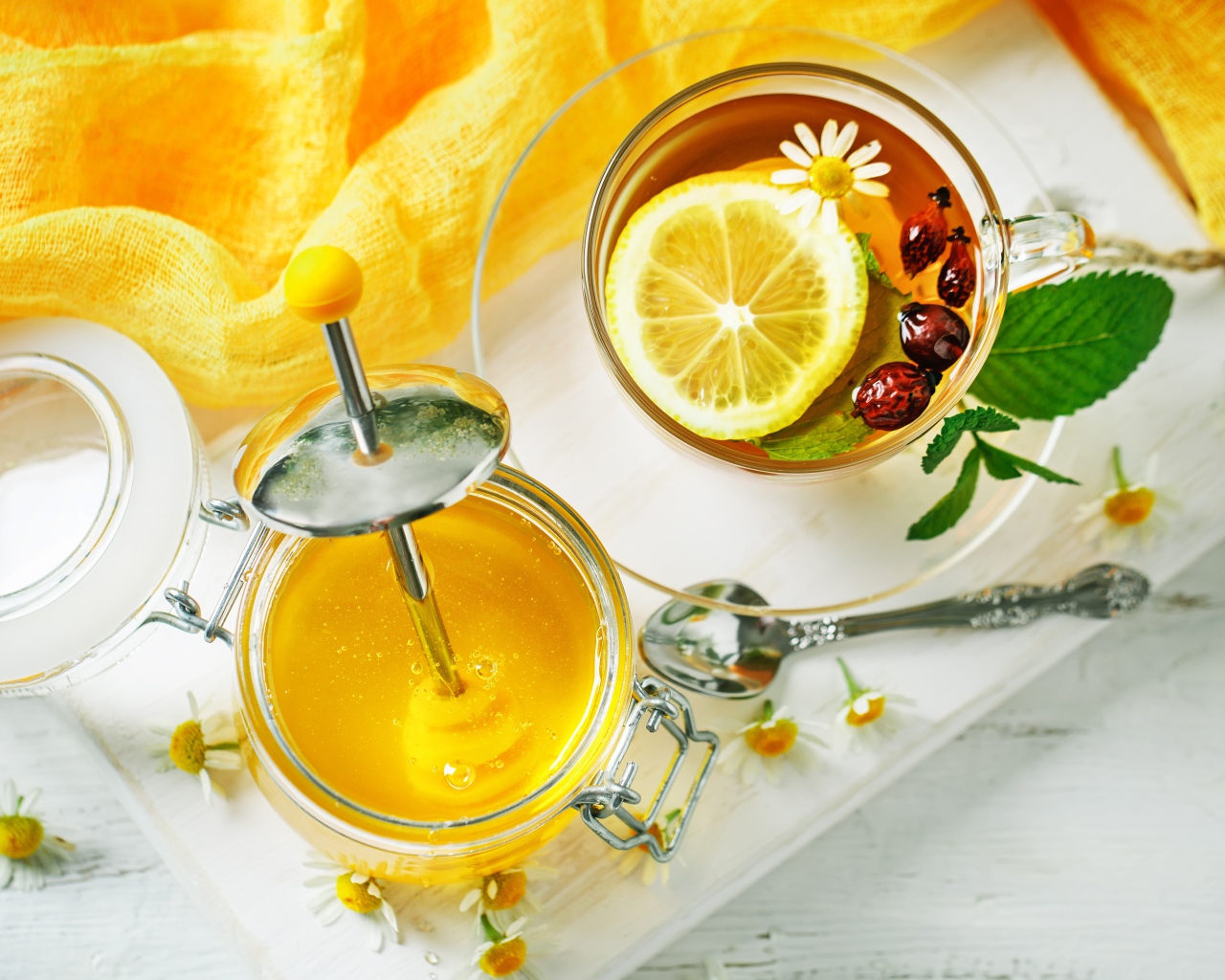 Чай с лимоном и шиповником на столе с медом