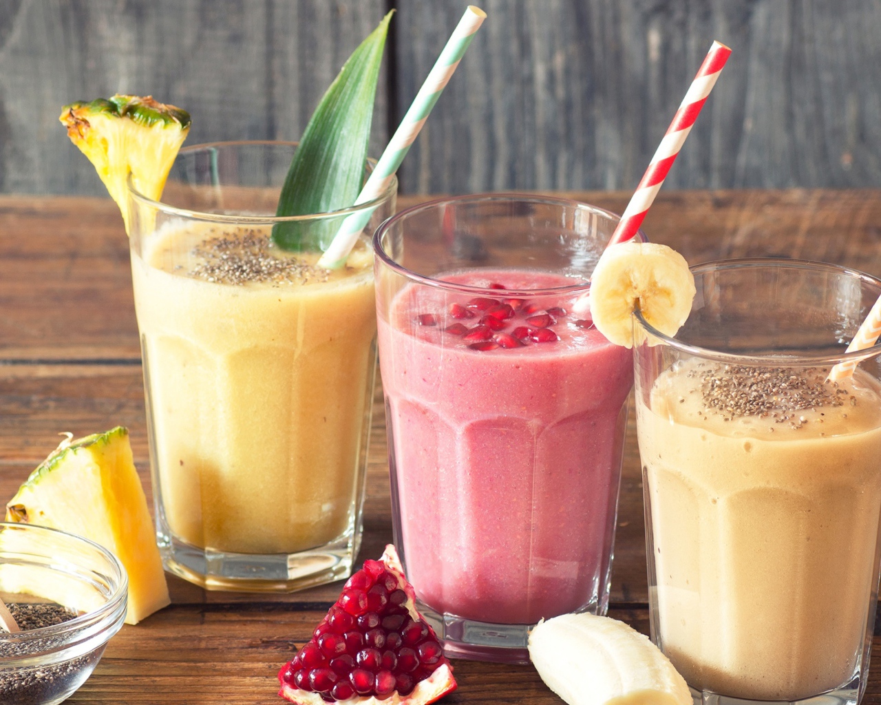 Три стакана смузи на столе с трубочками