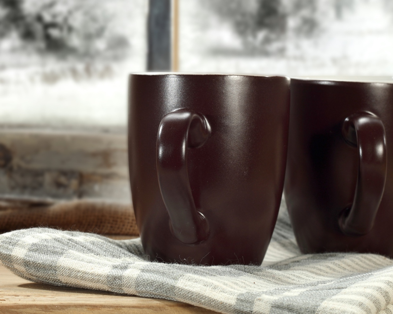 Две коричневые чашки кофе на столе с шарфом