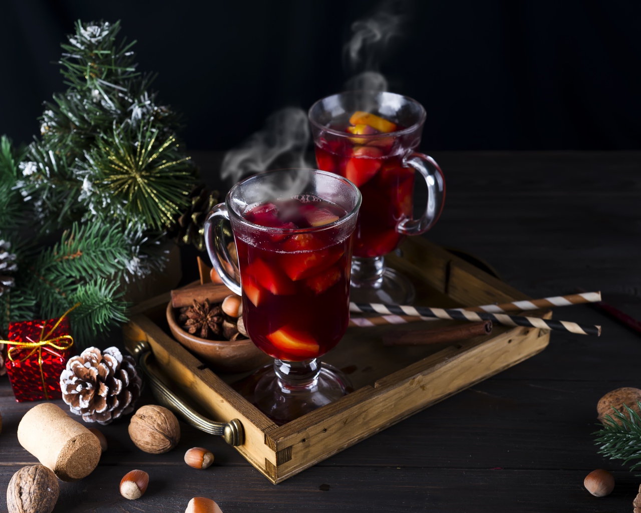 Два стакана горячего глинтвейна на столе с еловой веткой
