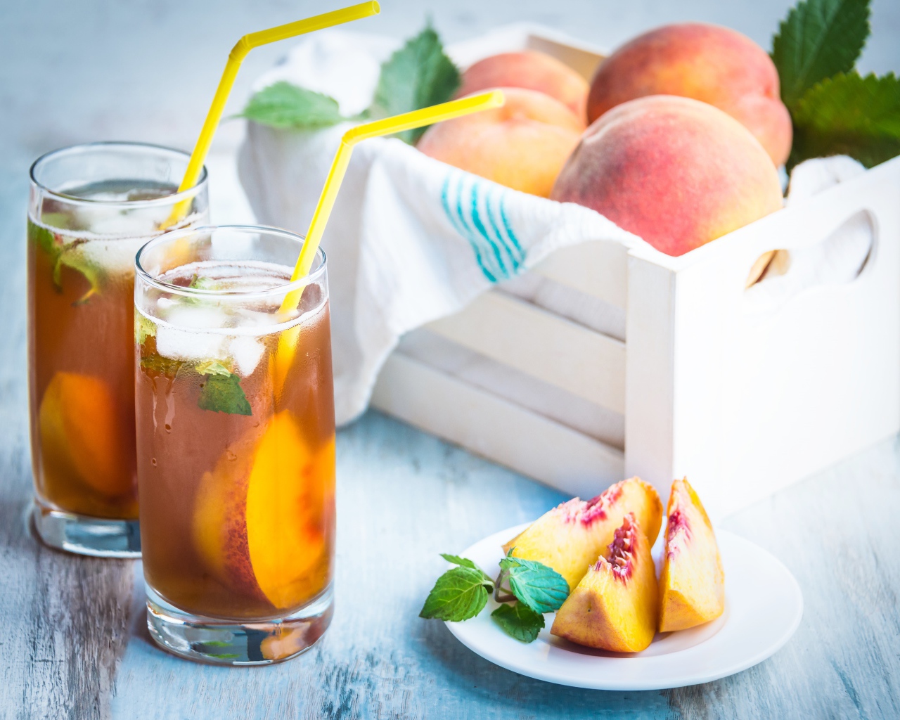 Два стакана сока на столе с персиками