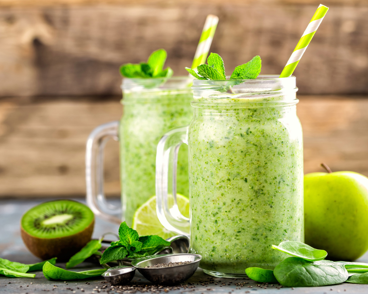 Два зеленых смузи на столе с киви, мятой и зеленым яблоком