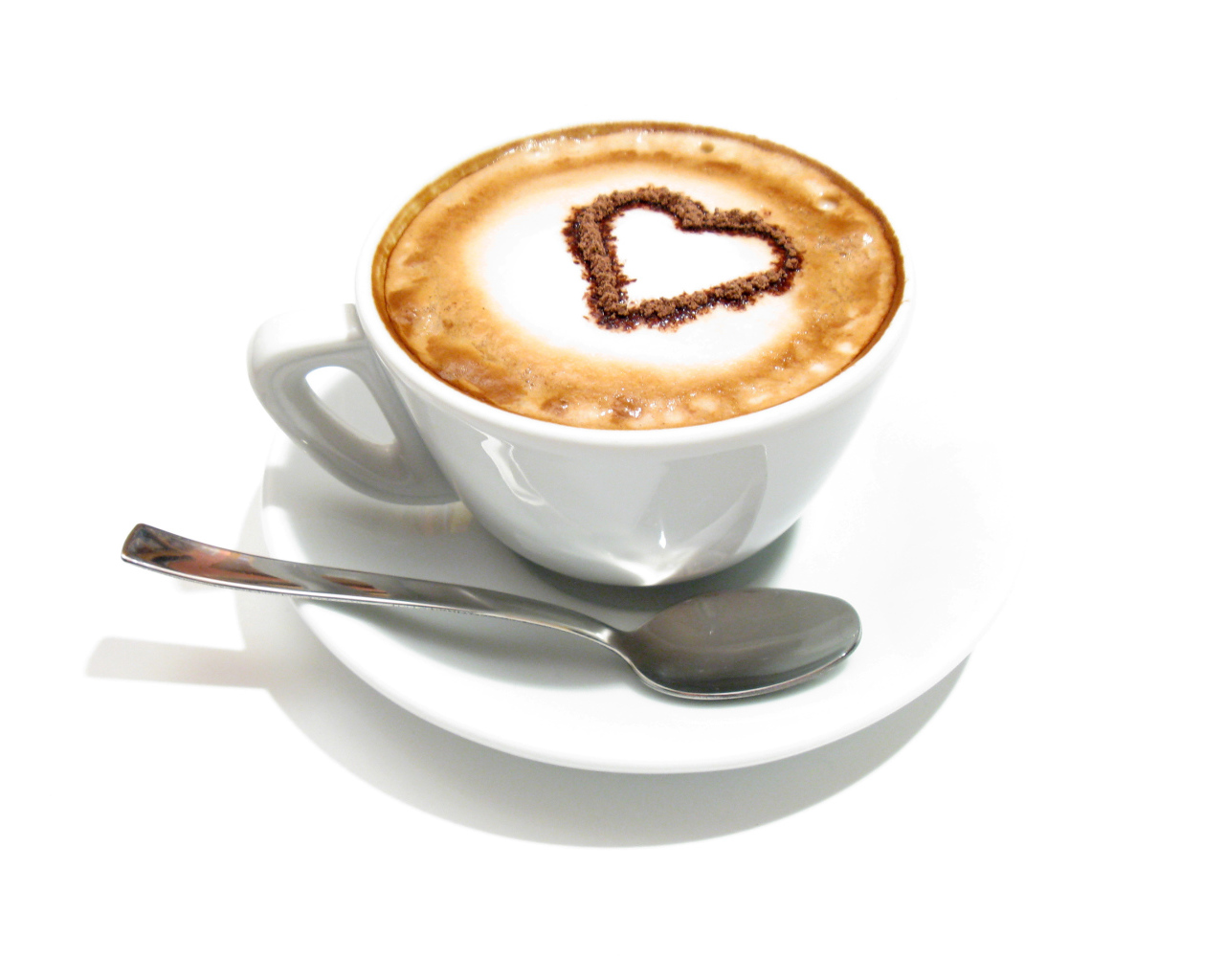 Белая чашка с капучино с сердцем из корицы на пене 