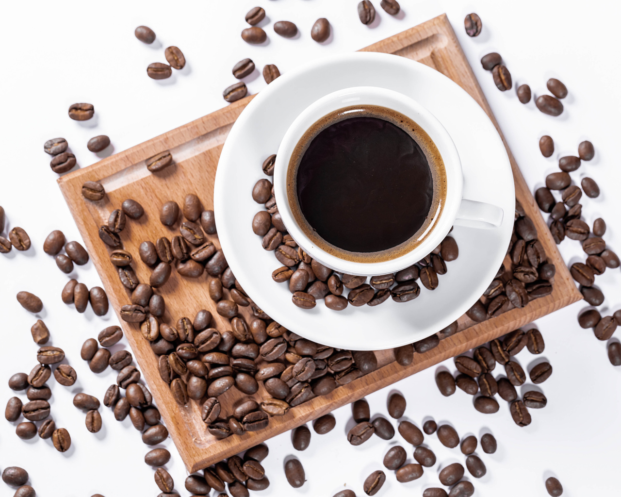 Белая чашка кофе на доске с кофейными зернами