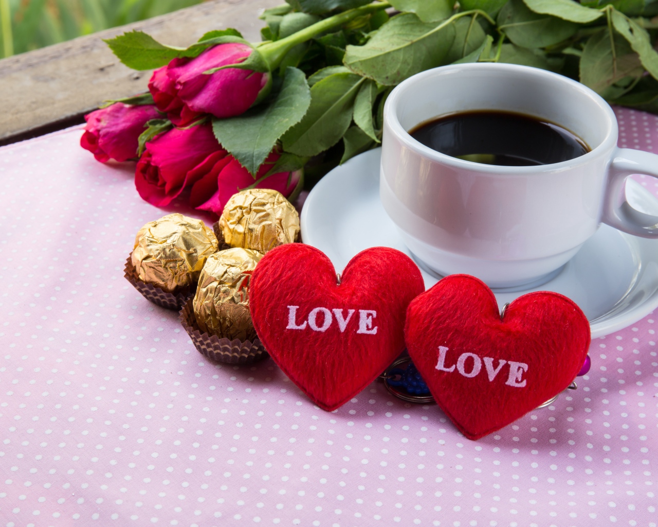 Белая чашка кофе на столе с букетом роз, конфетами и красными сердечками