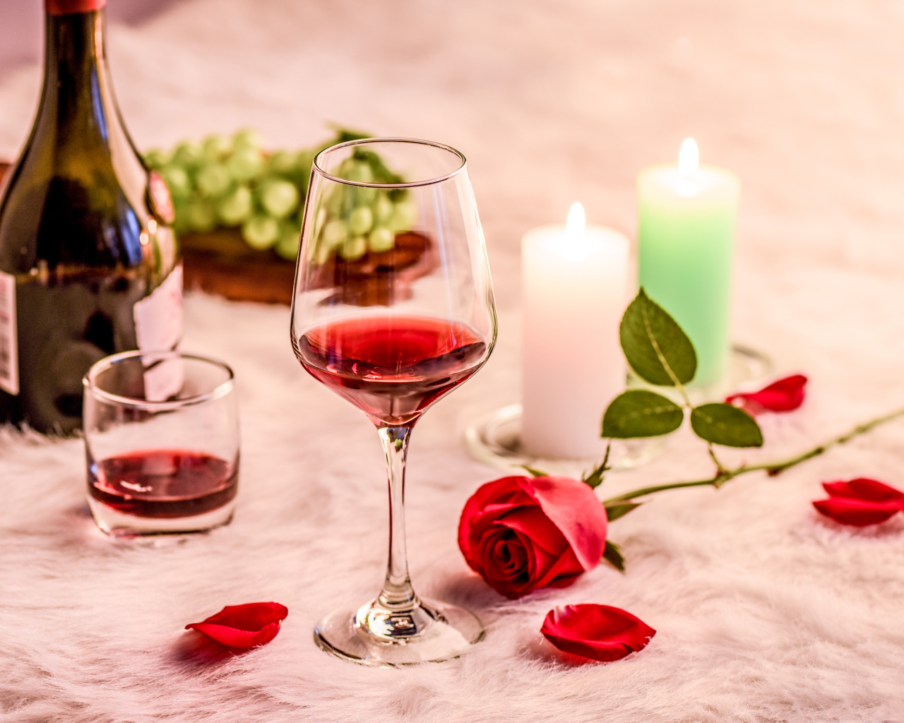 Вино на кровати с розой, виноградом и зажженными свечами