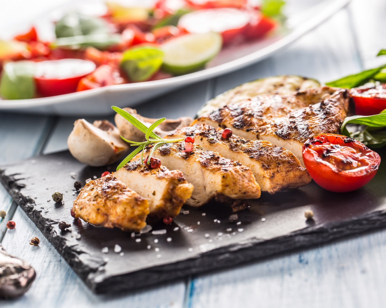 Запеченное куриное мясо на доске с помидорами 