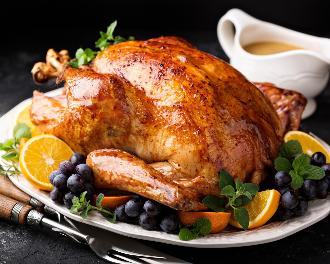 Запеченная курица на тарелке апельсинами и ягодами 