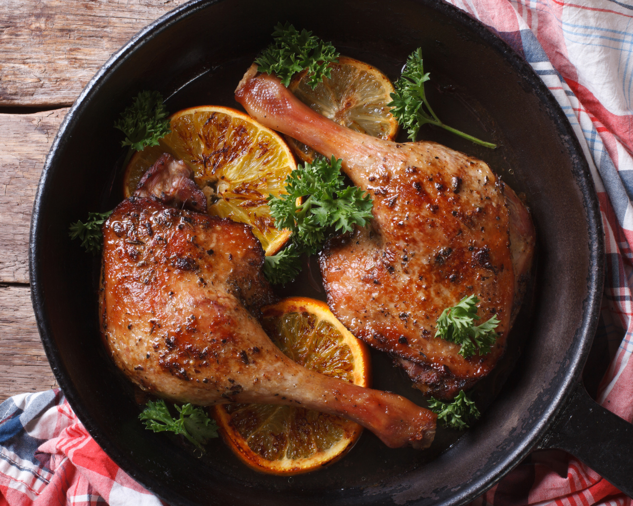 Куриные окорочка в сковороде с кольцами апельсина и петрушкой
