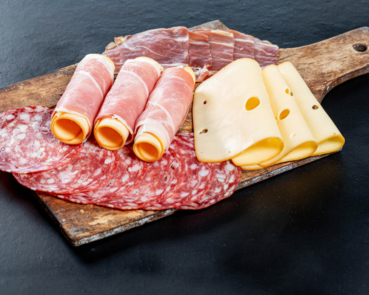 Ветчина на доске с колбасой и твердым сыром