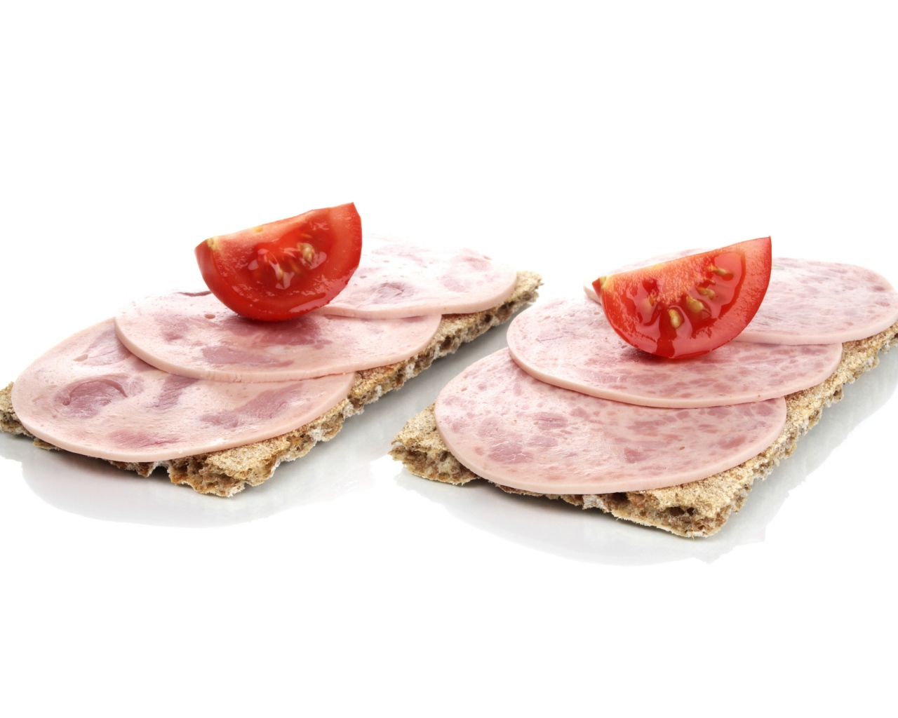 Тосты с колбасой и кусочками помидора на белом фоне