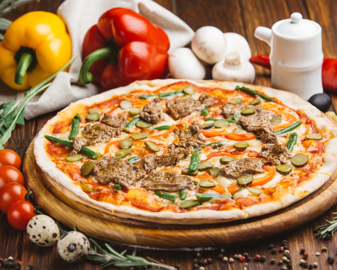 Свежая пицца с мясом и огурцами на столе с овощами