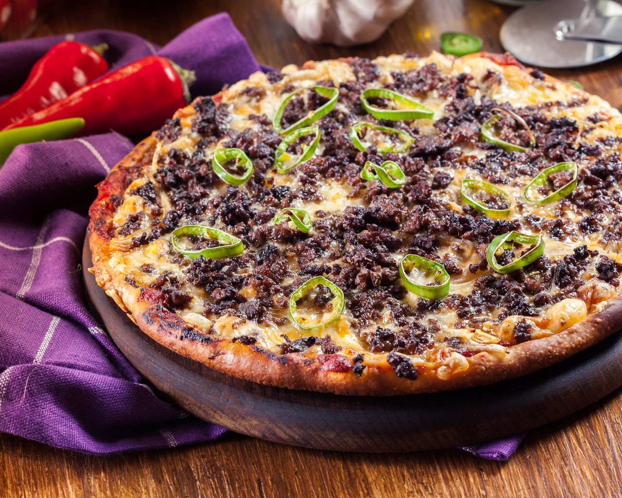 Пицца на доске с мясом и перцем 