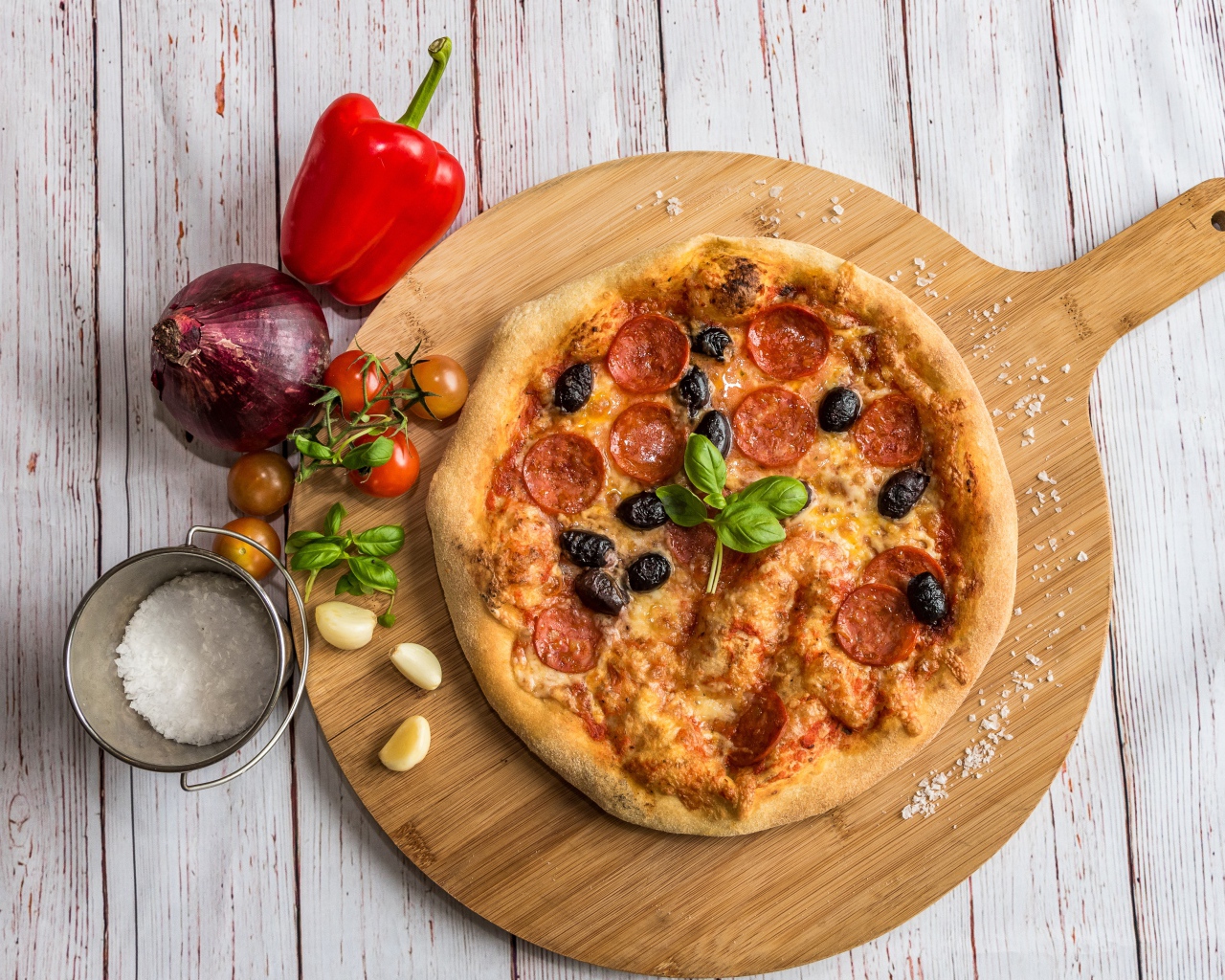 Пицца на доске с овощами и солью 