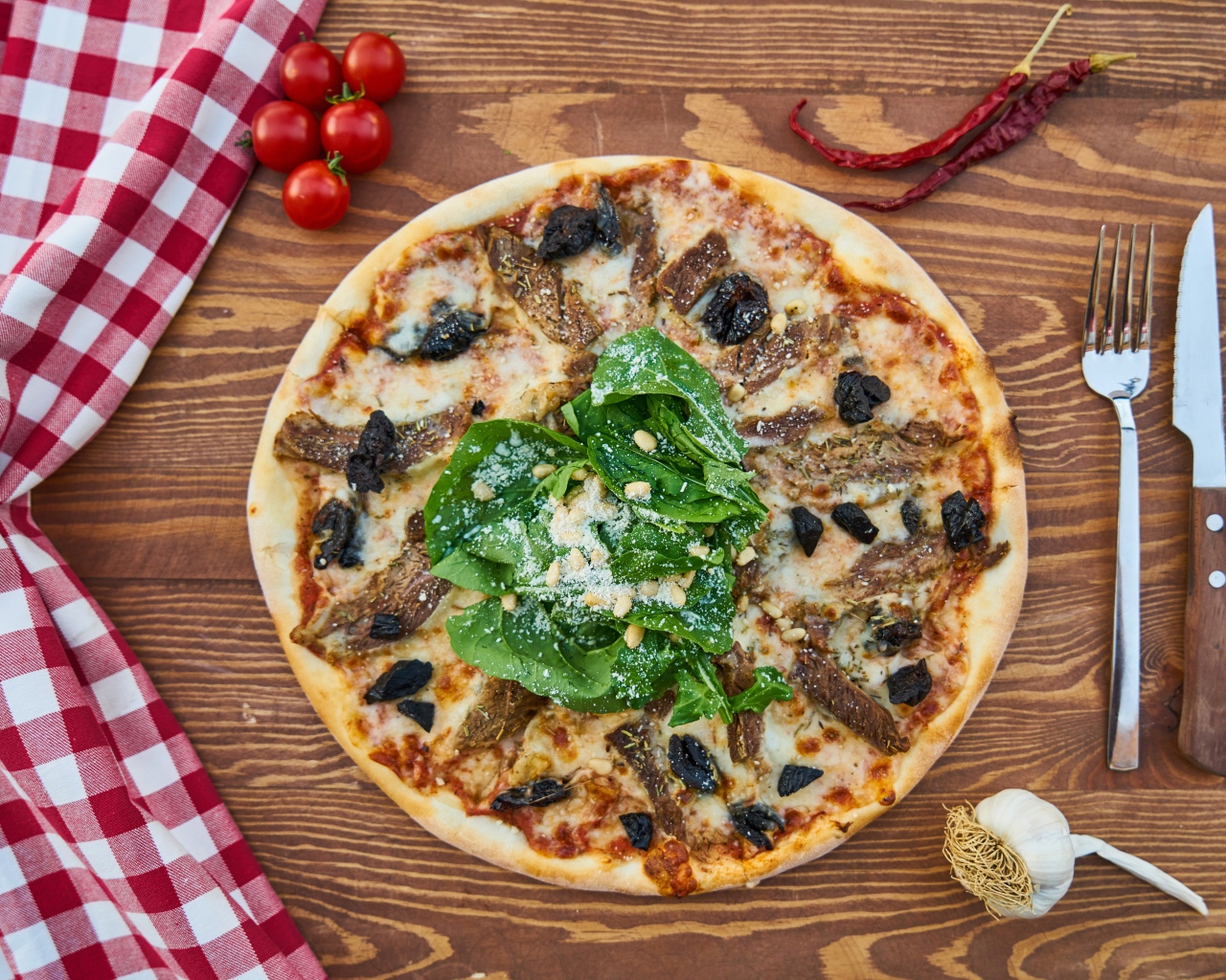 Пицца с мясом и шпинатом на столе 