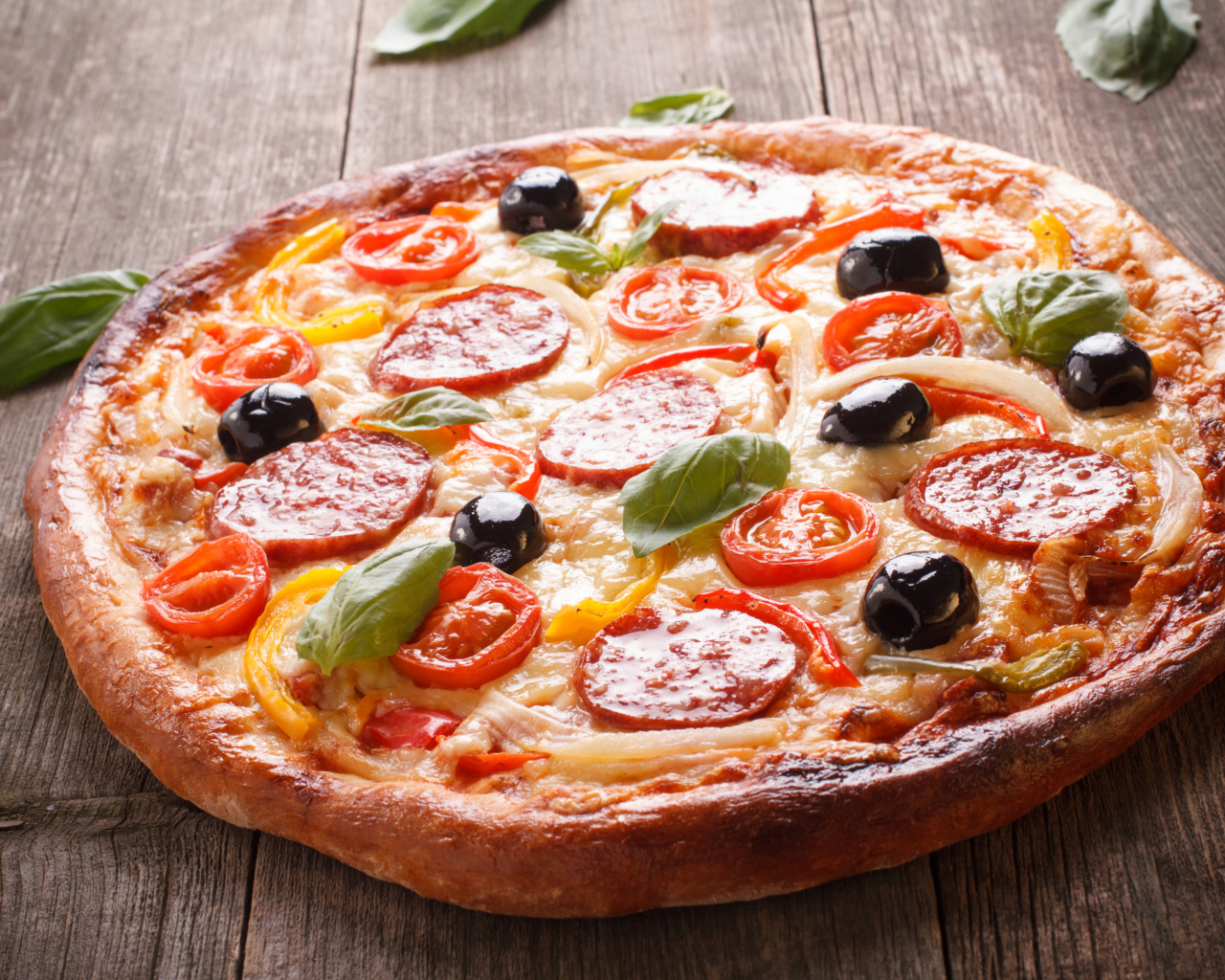 Румяная пицца с колбасой, помидорами, оливками и сыром