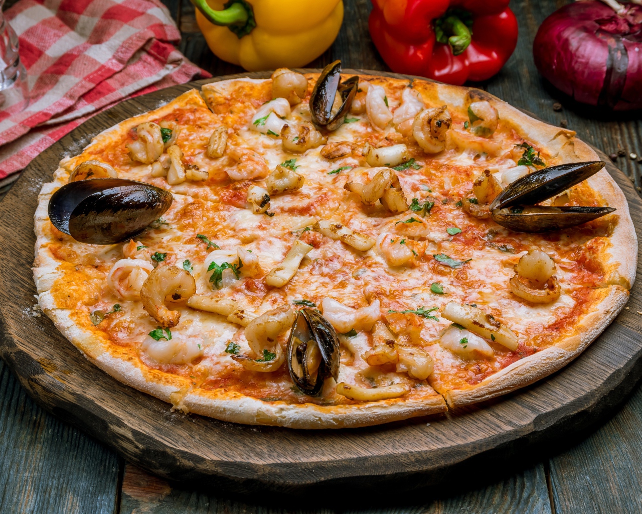 Вкусная пицца с морепродуктами на деревянной доске