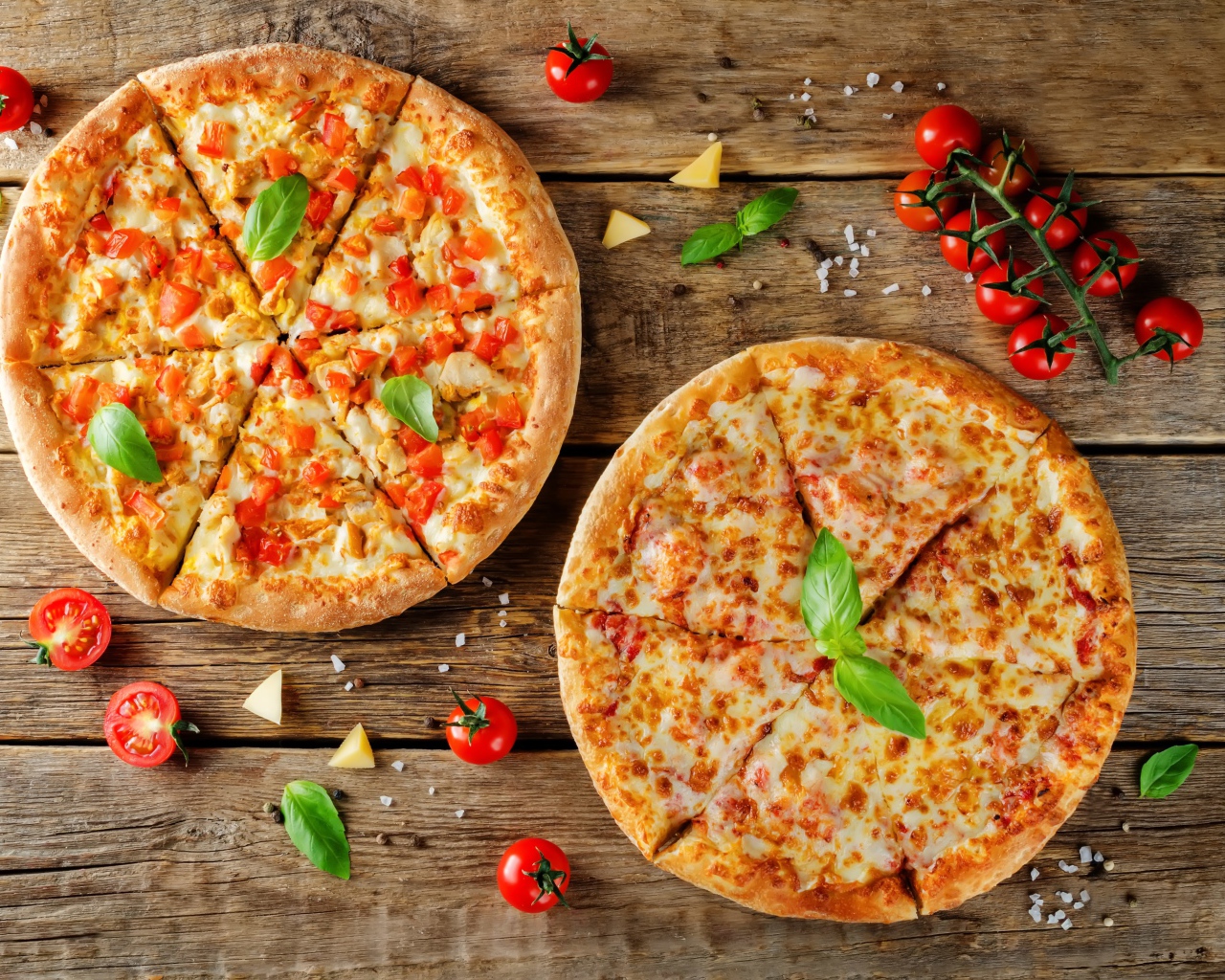 Две пиццы с сыром и болгарским перцем на столе с помидорами