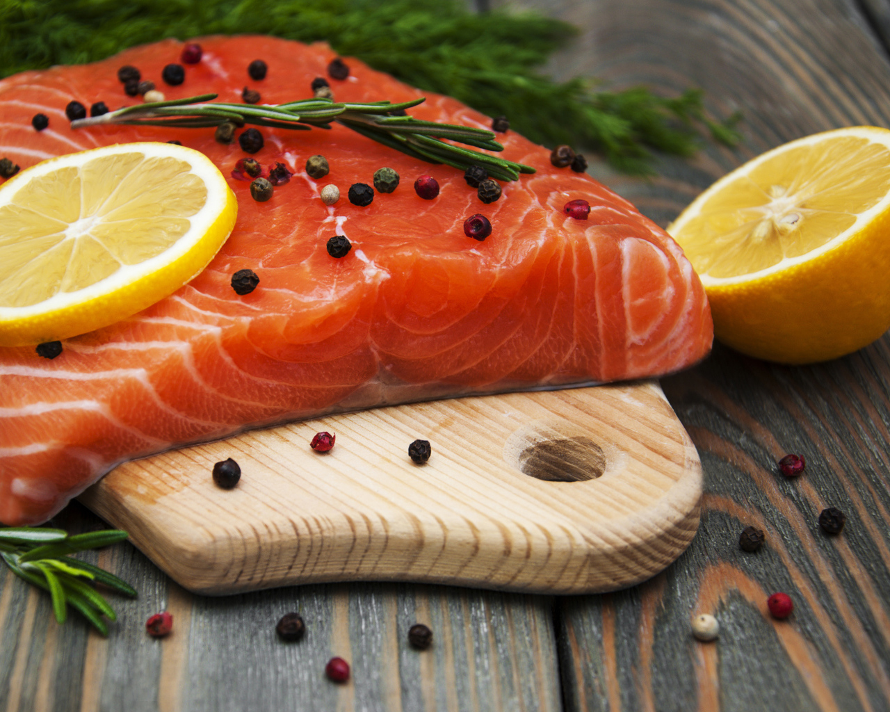 Кусок красной рыбы с лимоном и черным перцем