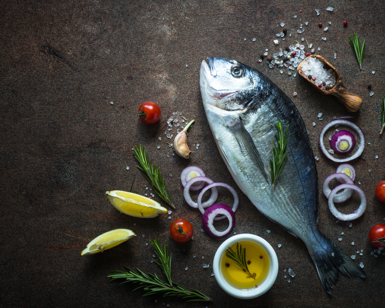 Свежая рыба на столе с овощами и специями 