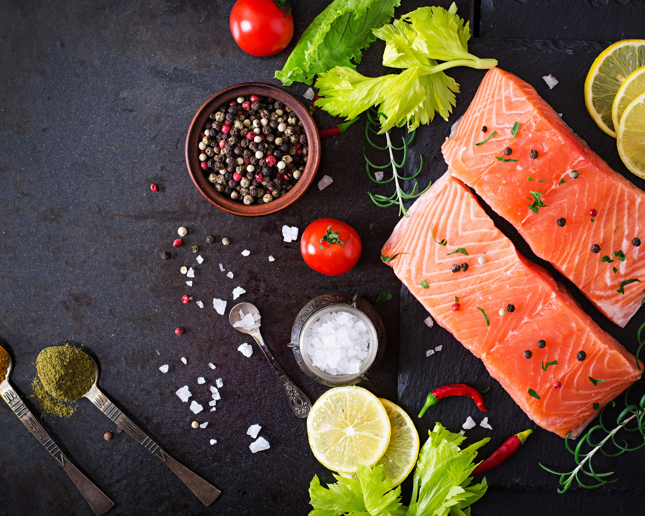 Куски красной рыбы на столе с лимоном и специями