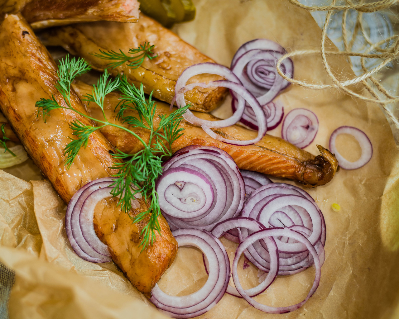 Копченое филе рыбы на бумаге с луком