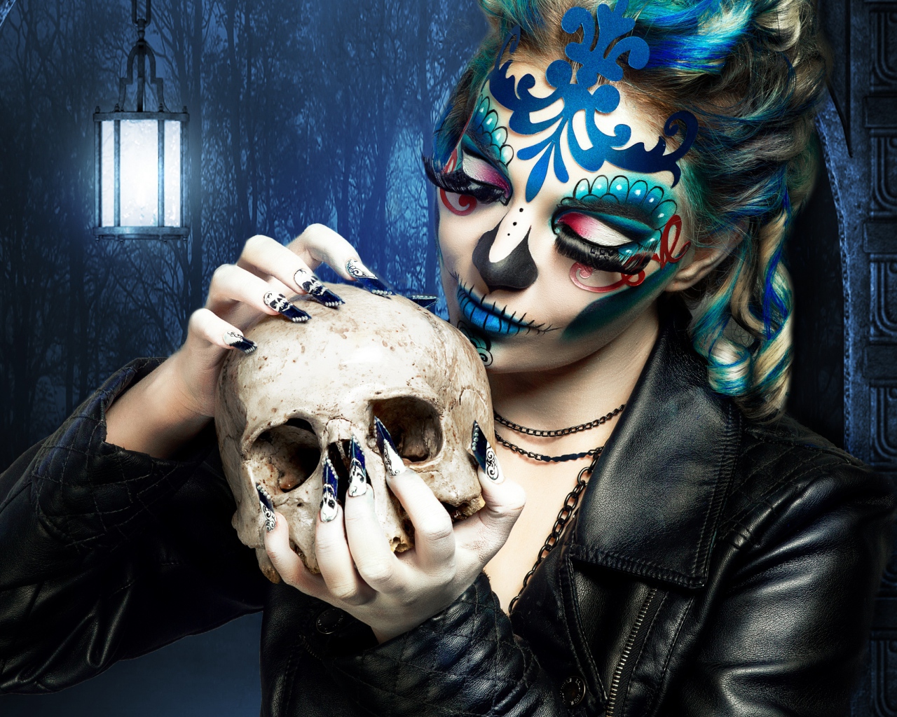 Girl with a make-up on the face with a skull in his hands on Halloween