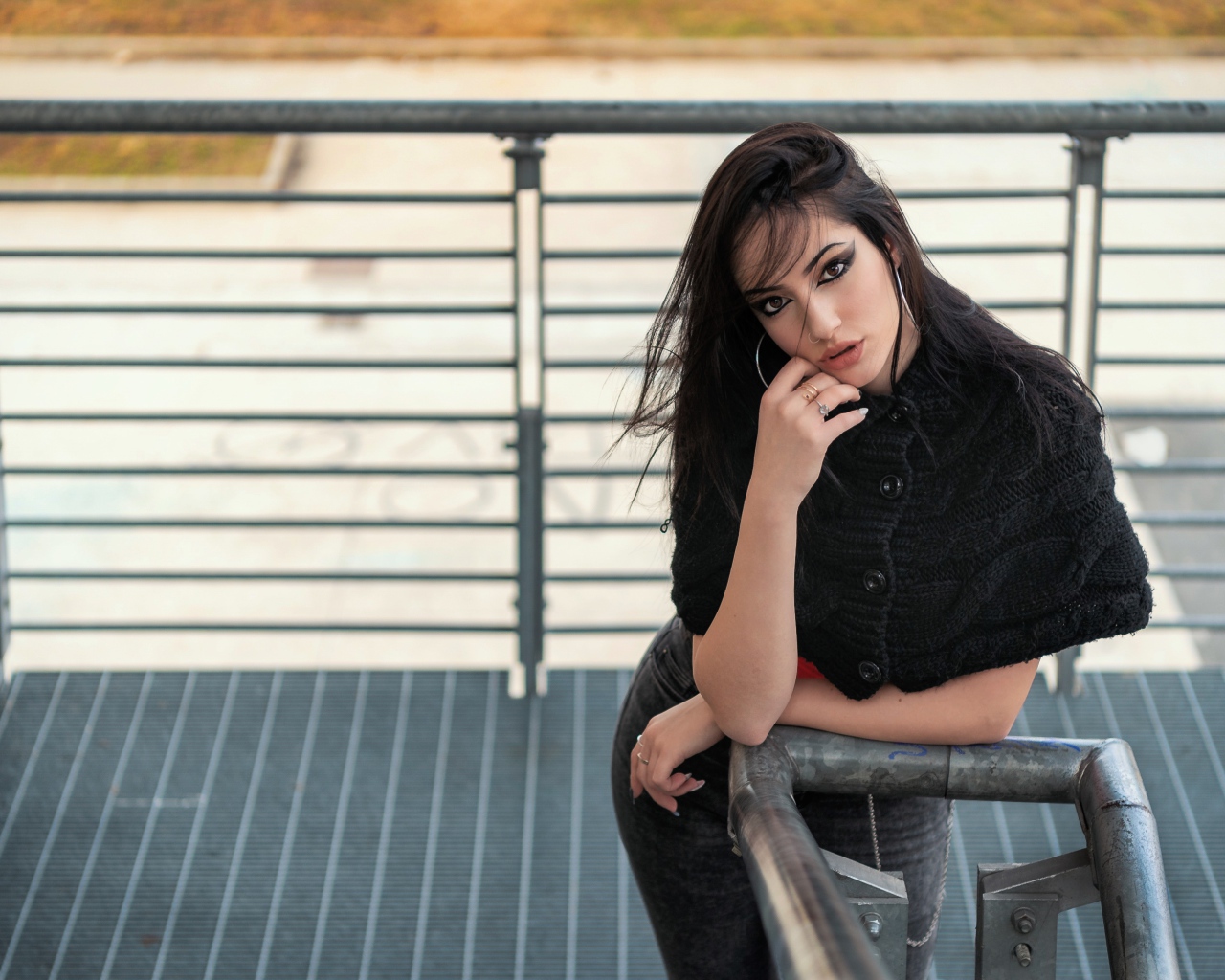 Красивая девушка стоит на ступеньках у перил 