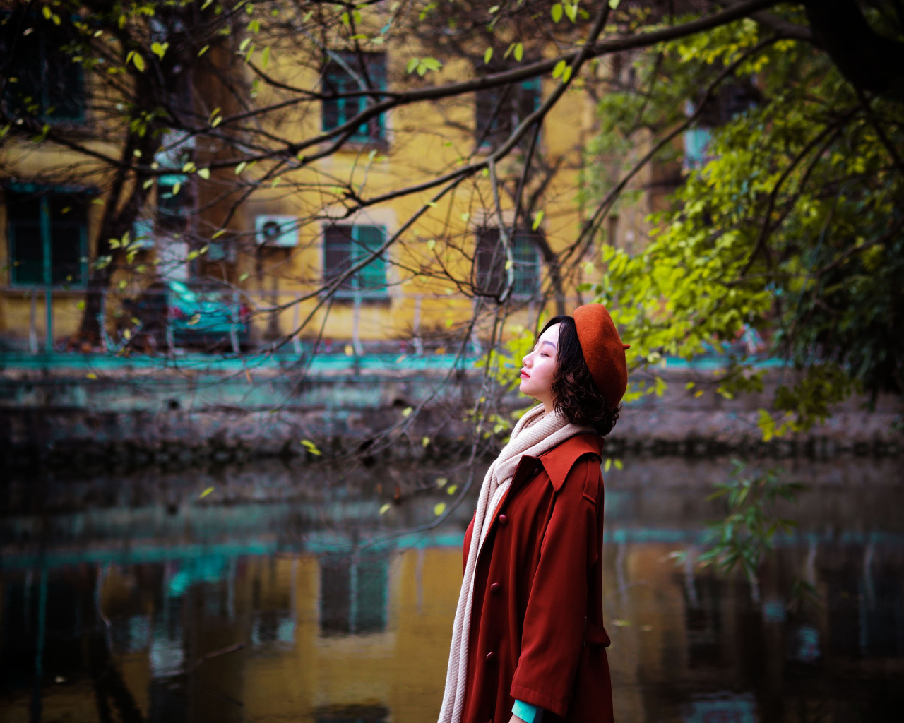 Девушка азиатка в красном пальто у воды