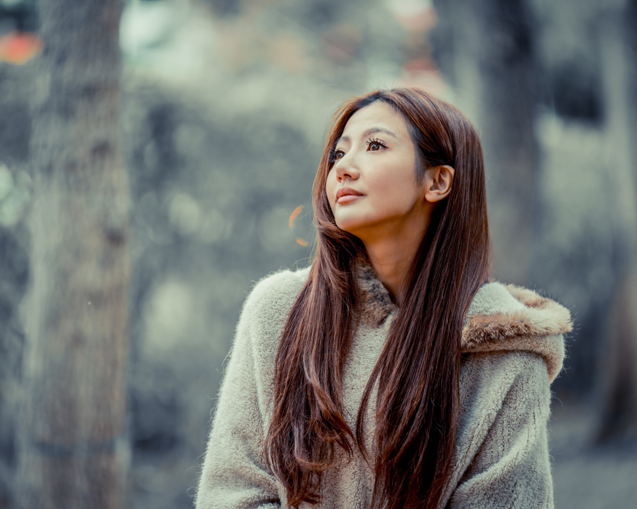 Длинноволосая девушка азиатка смотрит в сторону