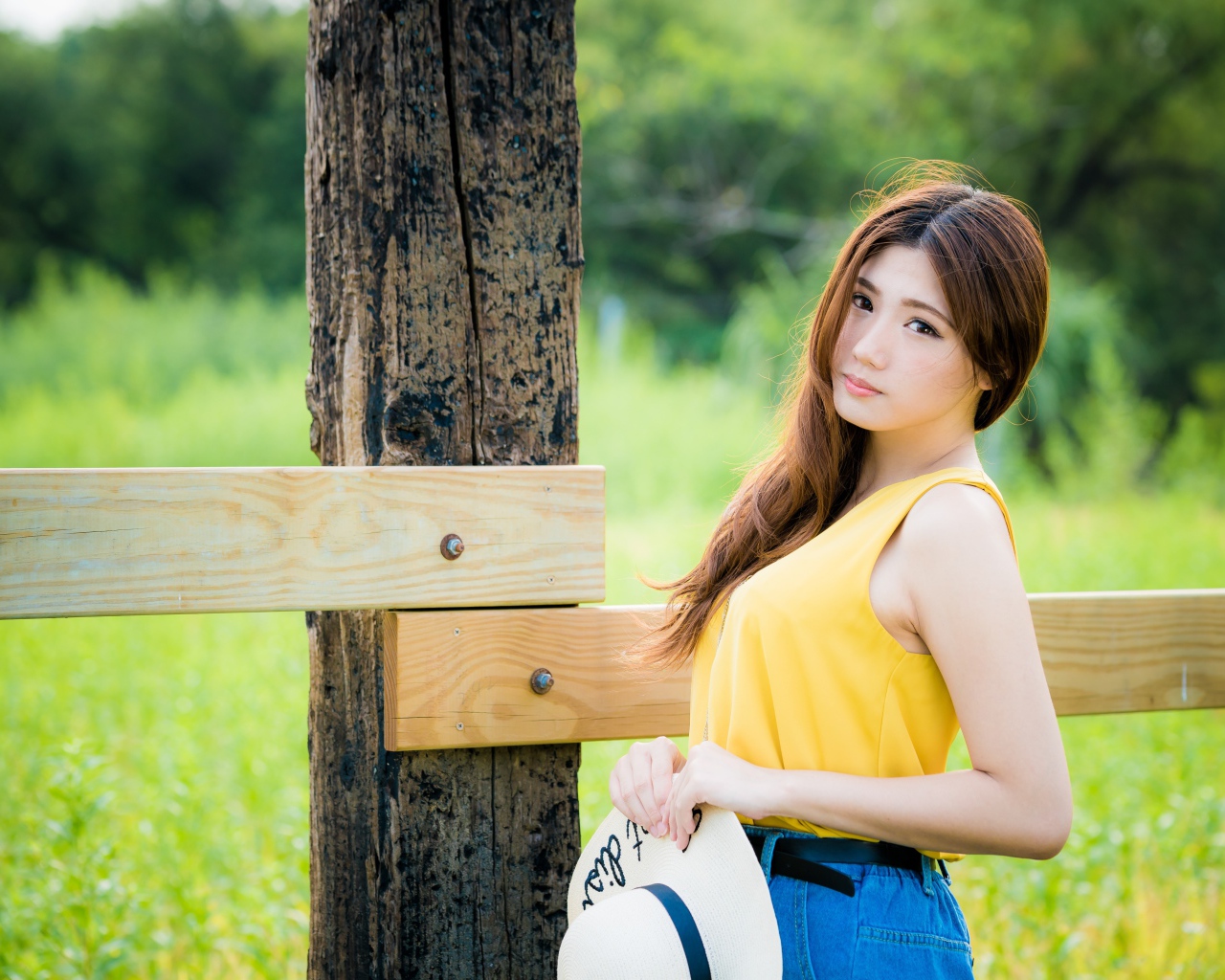 Красивая азиатка у деревянного столба 