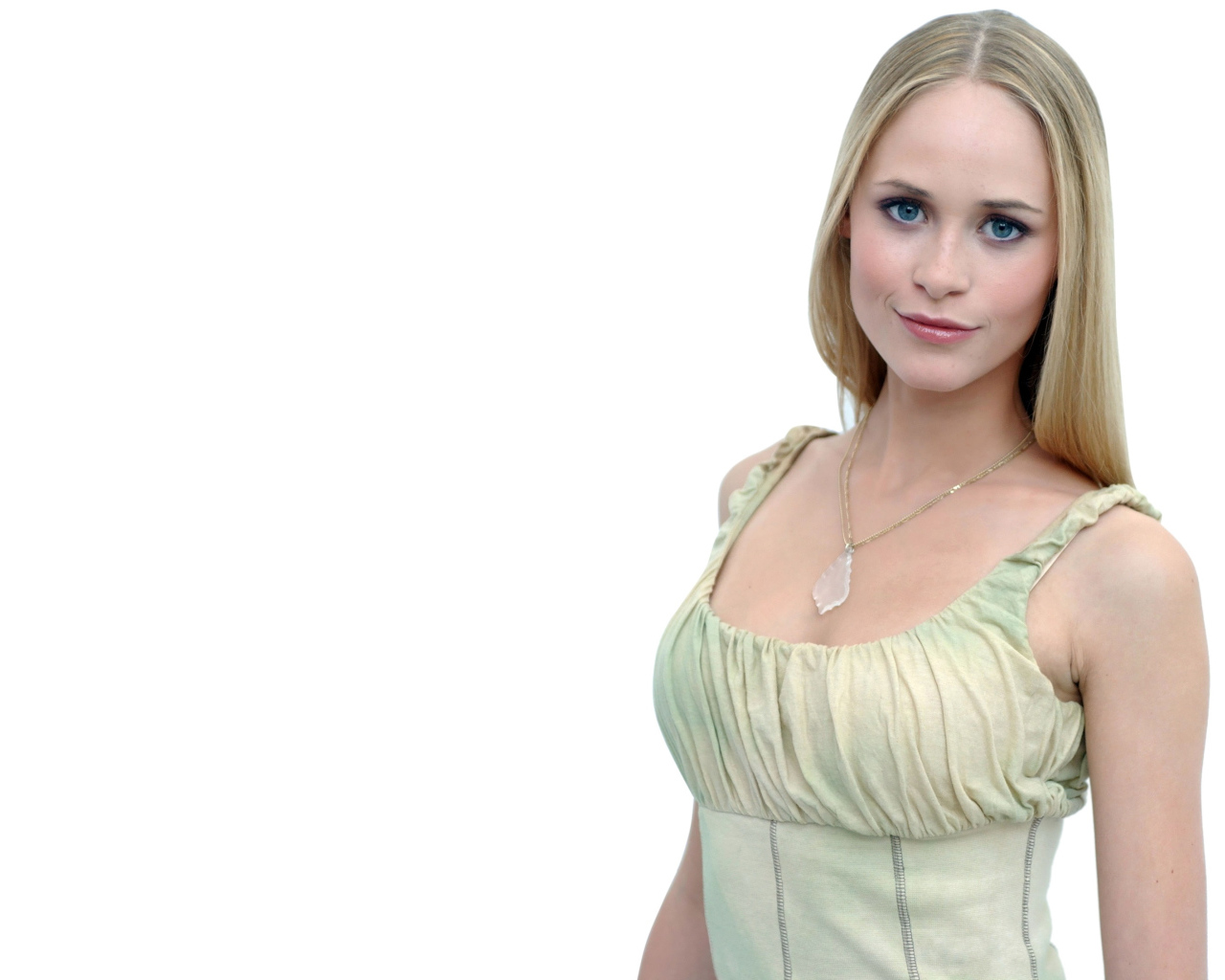 Красивая голубоглазая блондинка на белом фоне с кулоном на шее 