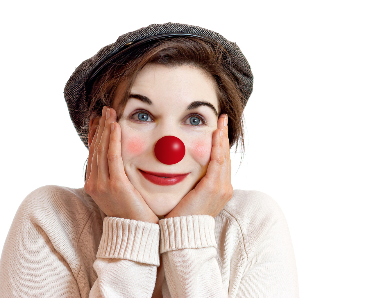 Красивая голубоглазая девушка в кепке с носом клоуна на белом фоне