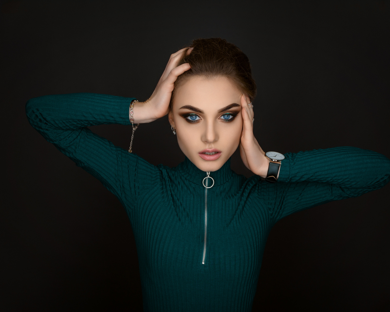 Красивая голубоглазая девушка в зеленом свитере на черном фоне