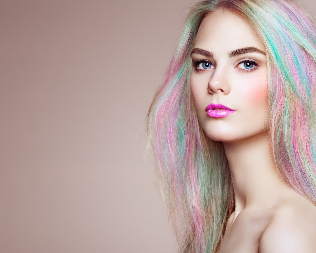 Красивая голубоглазая девушка с разноцветными волосами на сером фоне