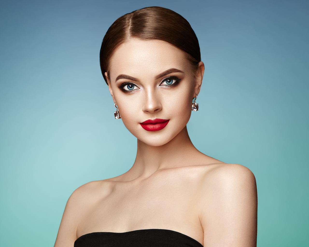 Красивая голубоглазая девушка с накрашенными губами и серьгами в ушах