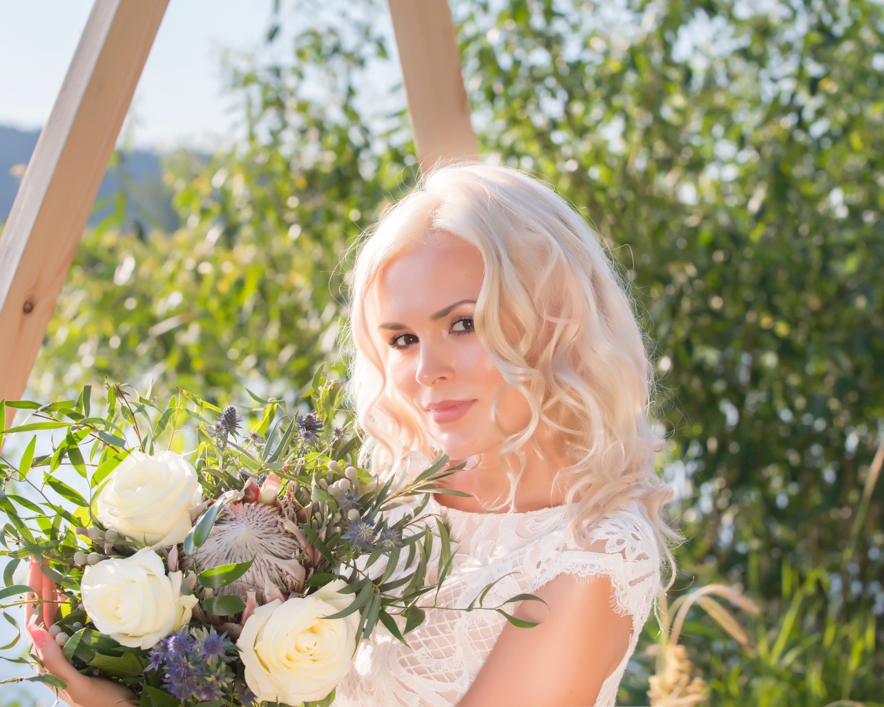 Красивая кареглазая блондинка с букетом в руках 