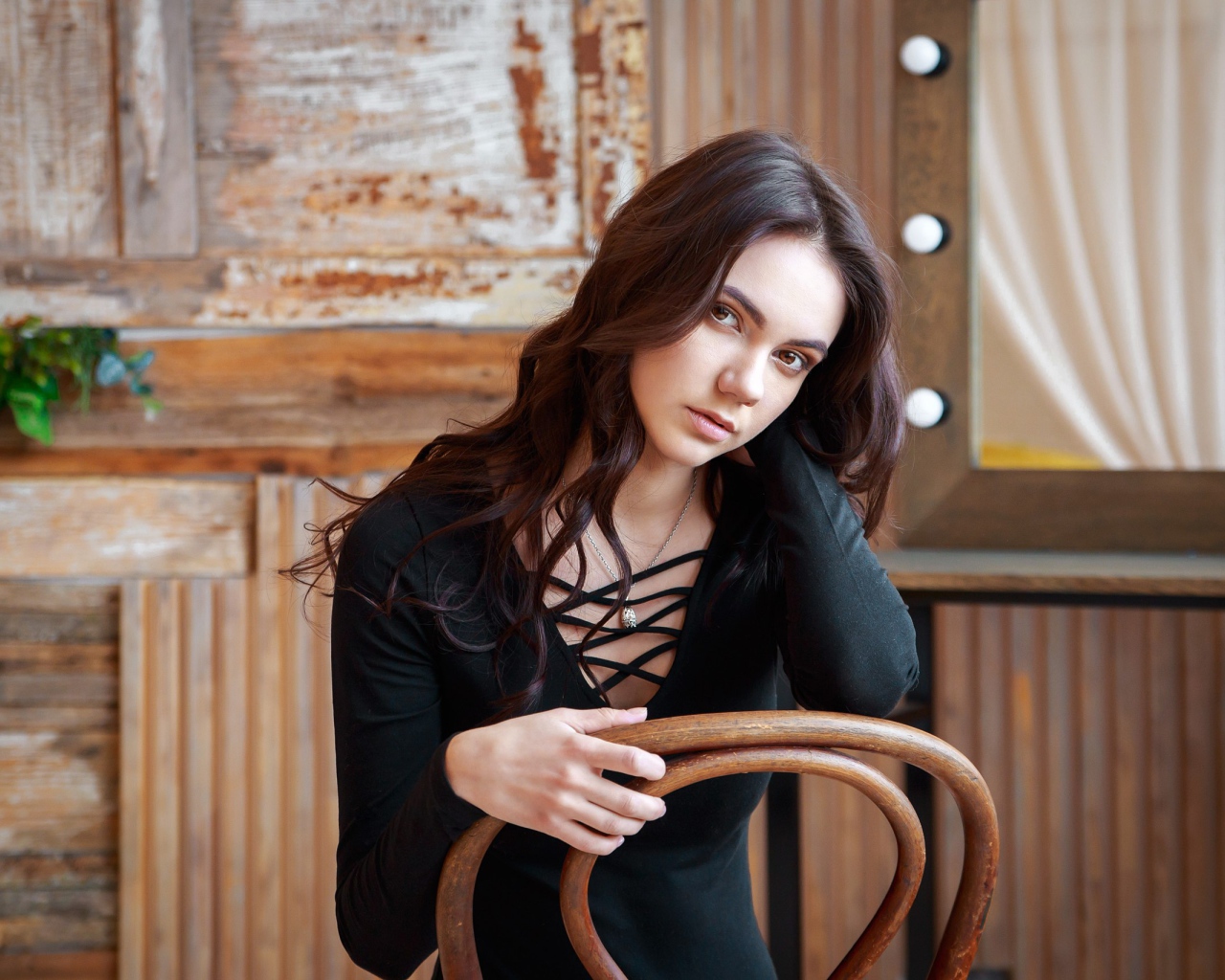 Красивая кареглазая девушка сидит на стуле