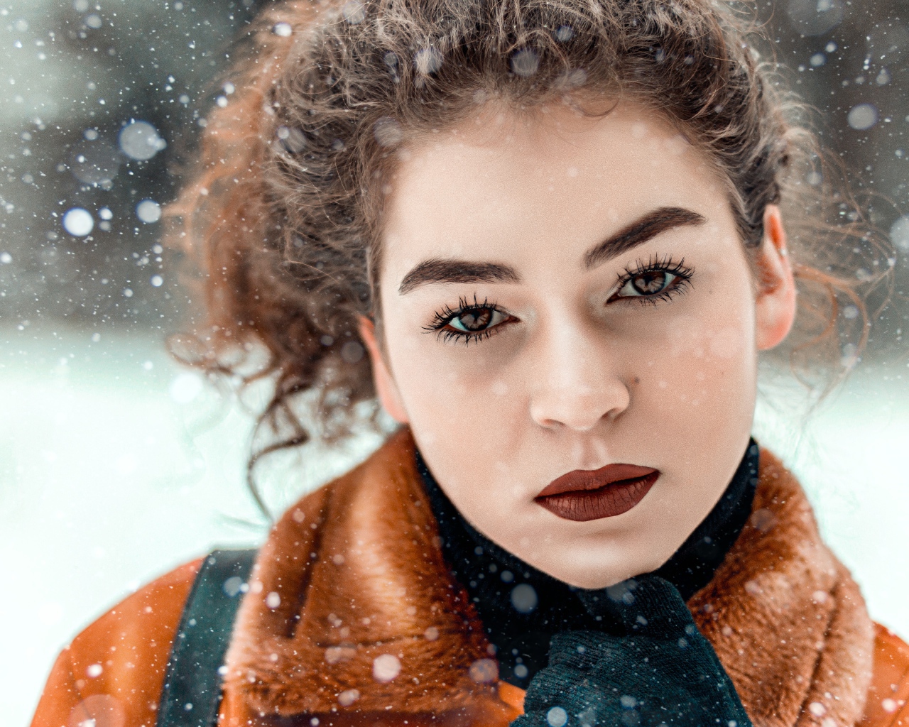 Красивая кареглазая девушка стоит на улице зимой