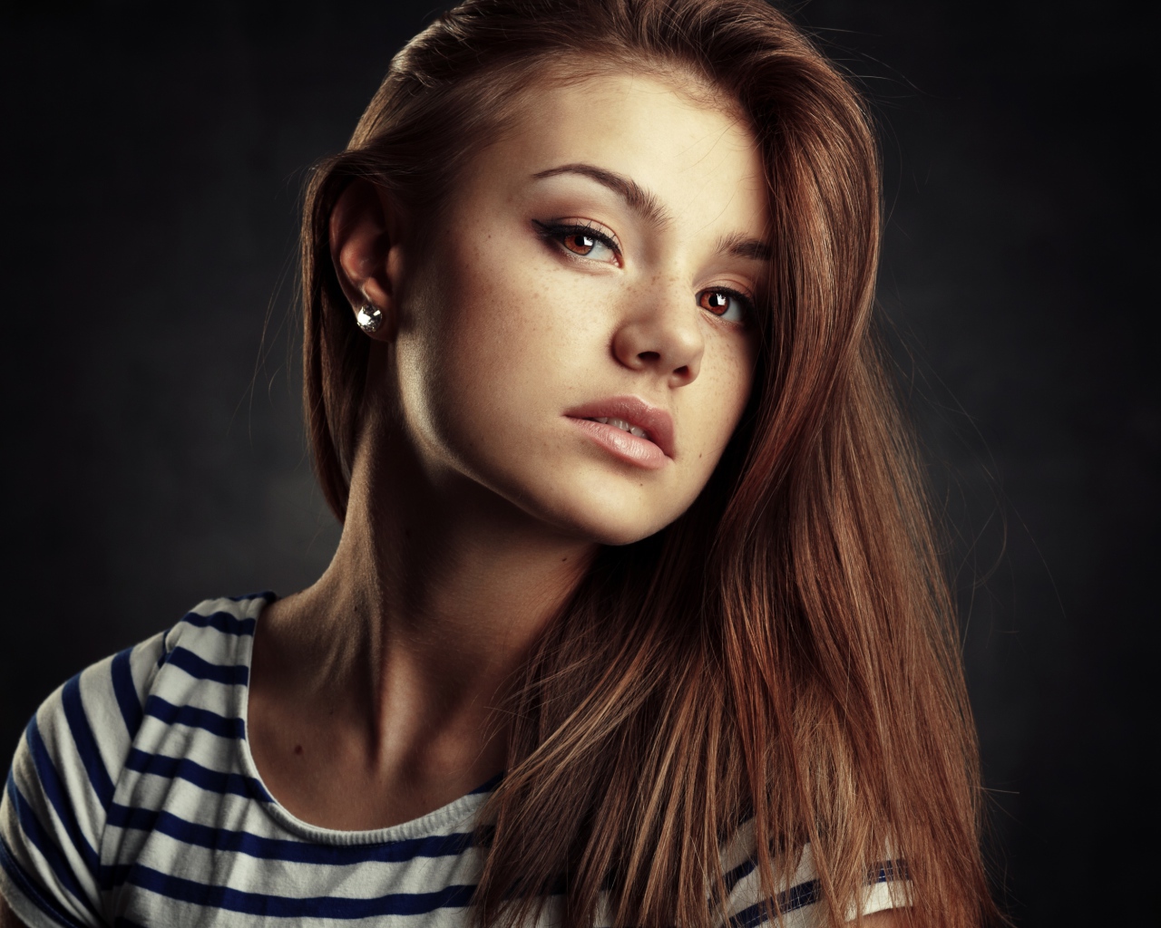 Красивая кареглазая девушка с русыми волосами на сером фоне