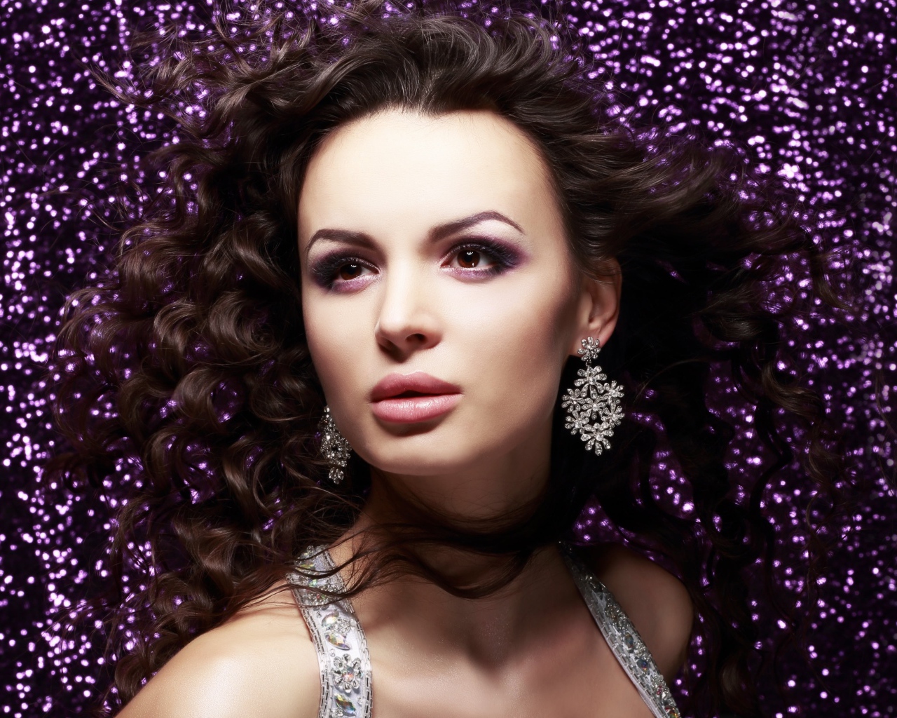 Красивая шатенка на блестящем фоне