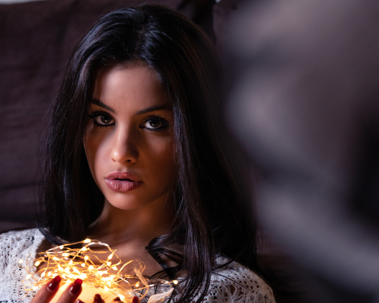 Красивая брюнетка с гирляндой в руках