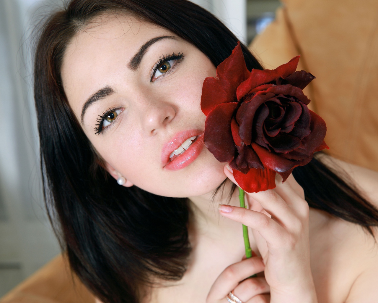 Красивая брюнетка с розой в руке крупным планом