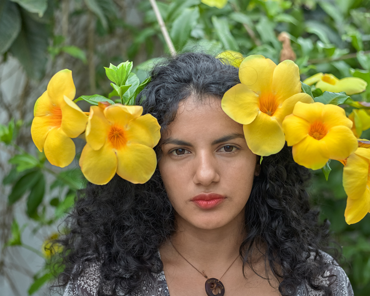Красивая брюнетка с большими желтыми цветами в волосах 