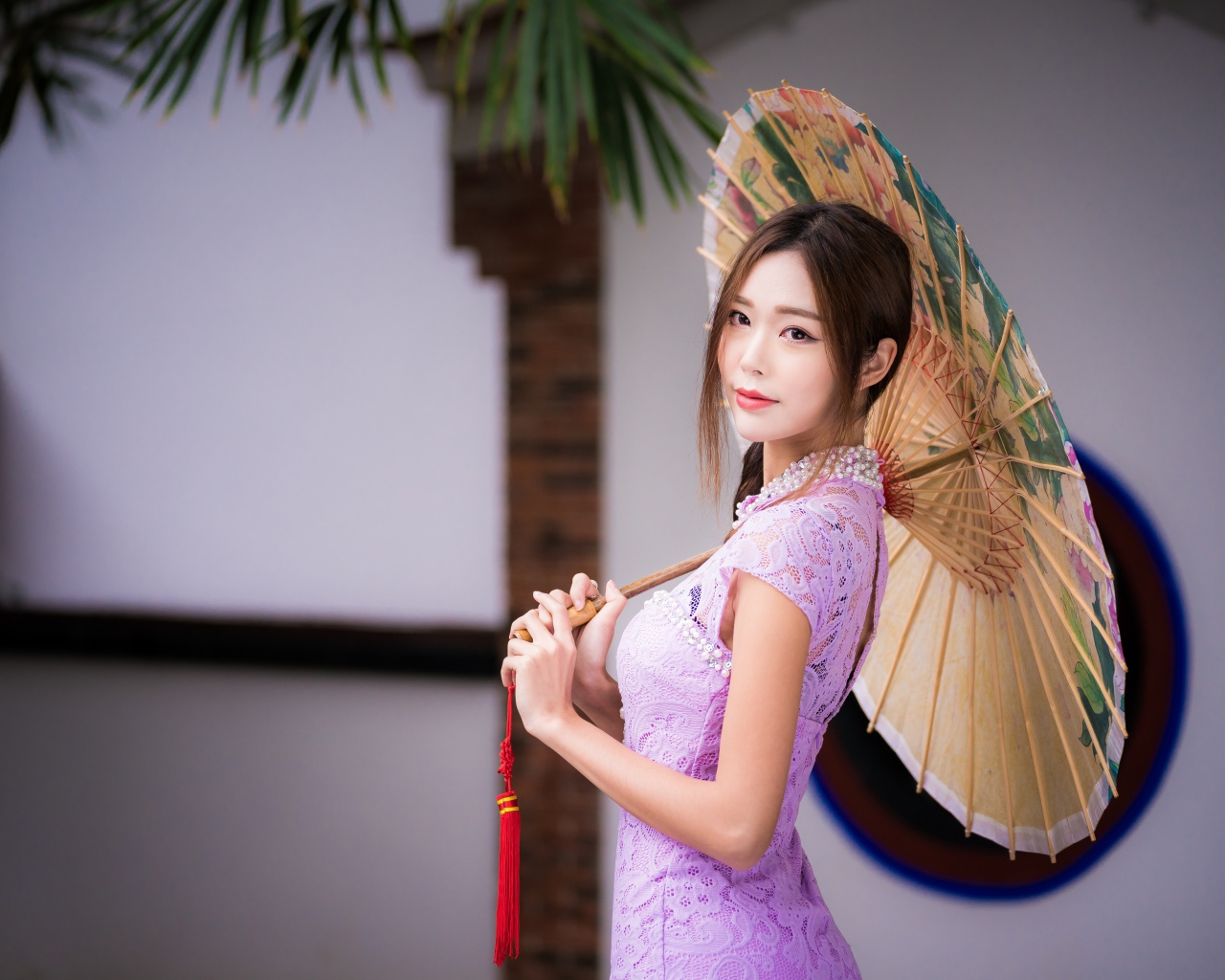 Красивая нежная азиатка в сиреневом платье с зонтом в руках